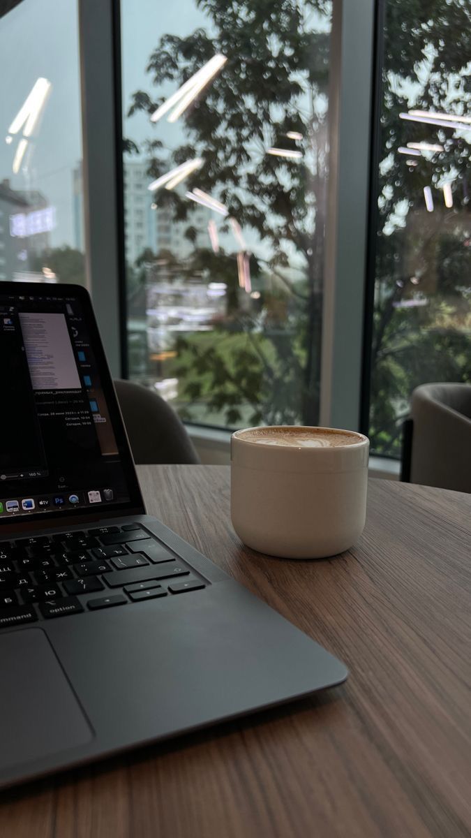 Laptop and coffee beside a window during tax work
