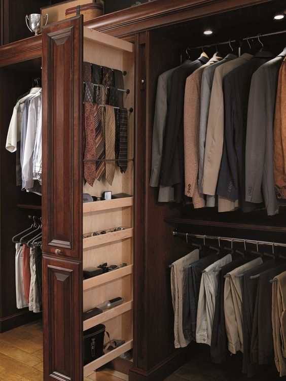 Warm wood closet with suits, shirts, trousers, ties, and accessories organized