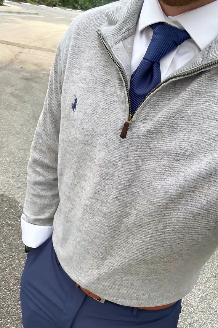 Gray quarter zip layered over a white shirt and navy tie