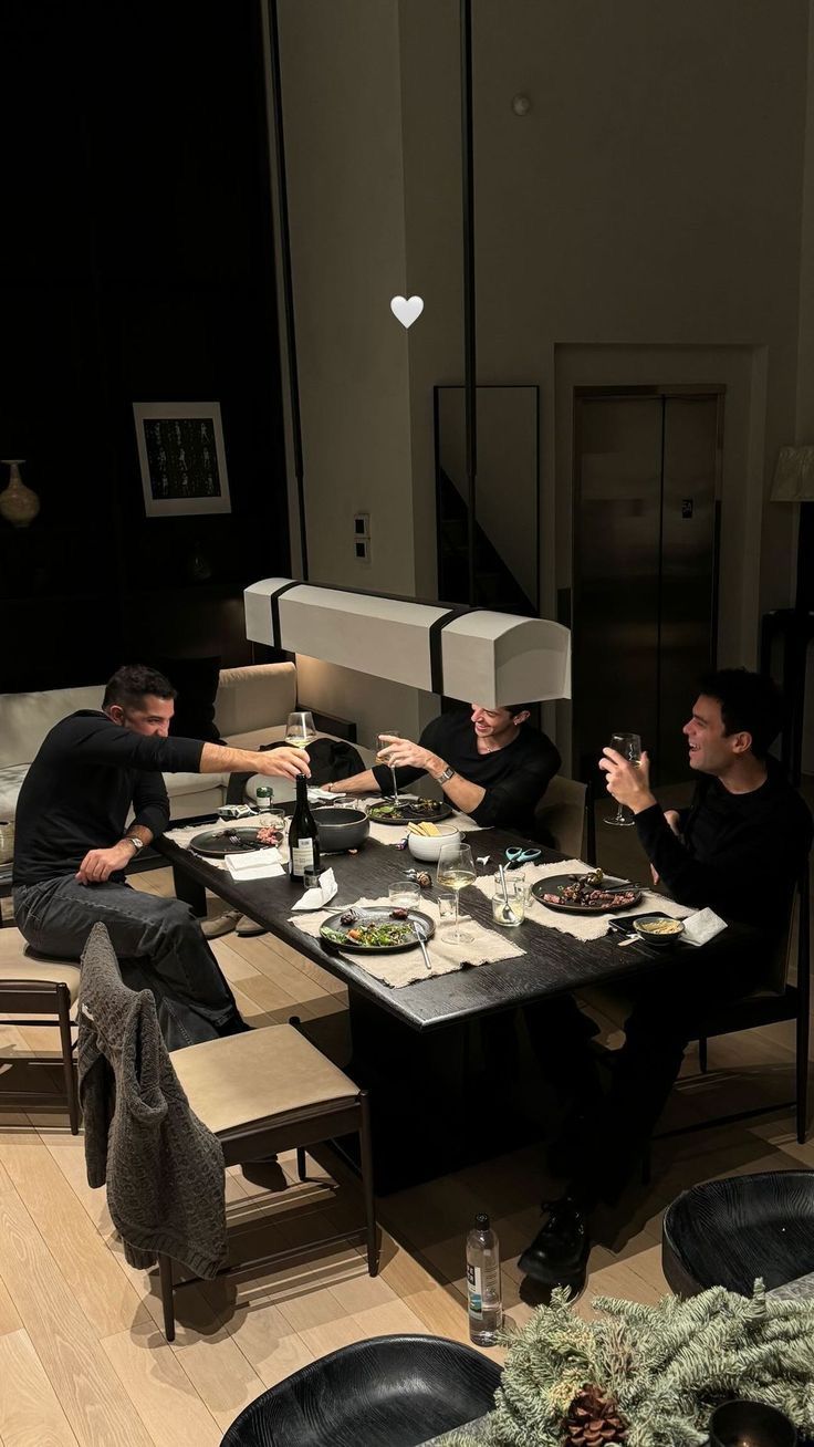 Friends eating dinner and raising glasses around a table