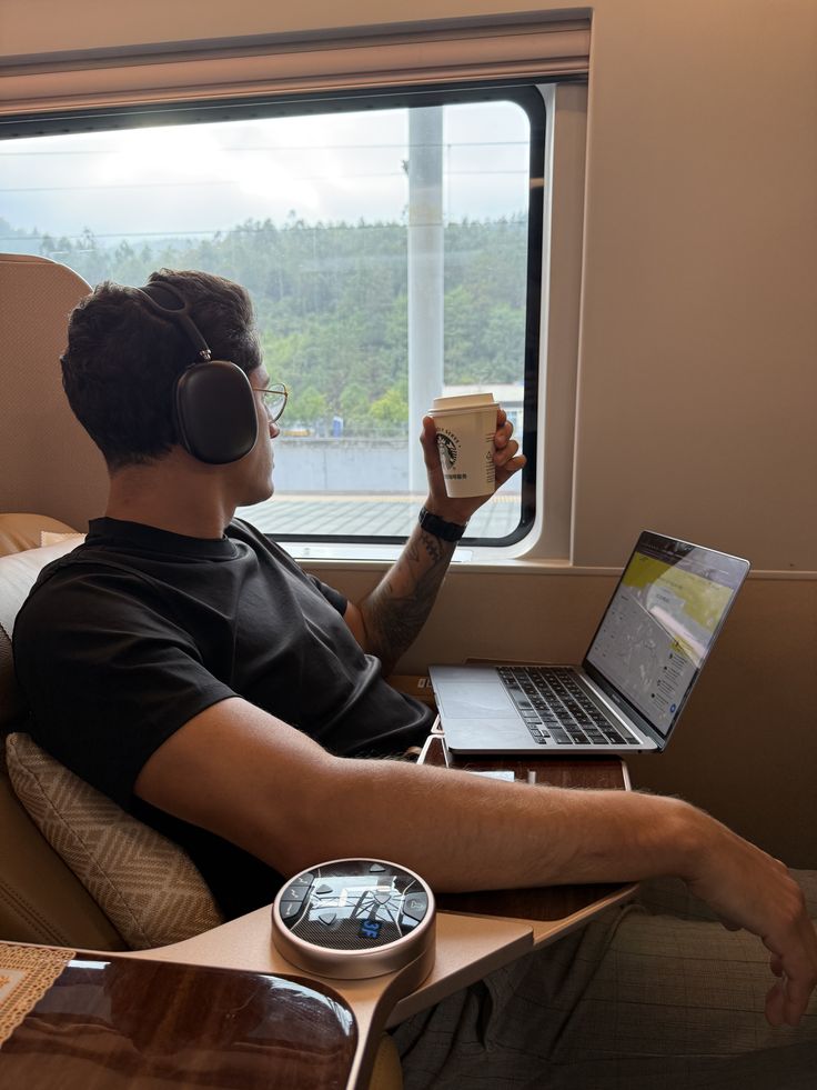 Man with laptop and coffee on a train