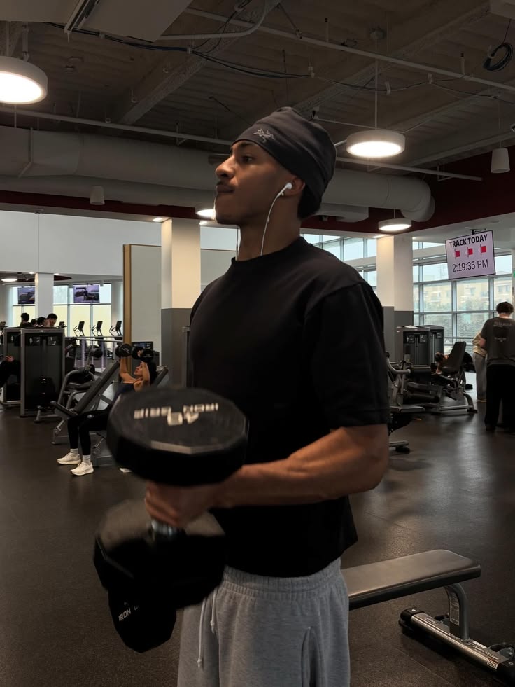 Man holding dumbbells with back muscles visible