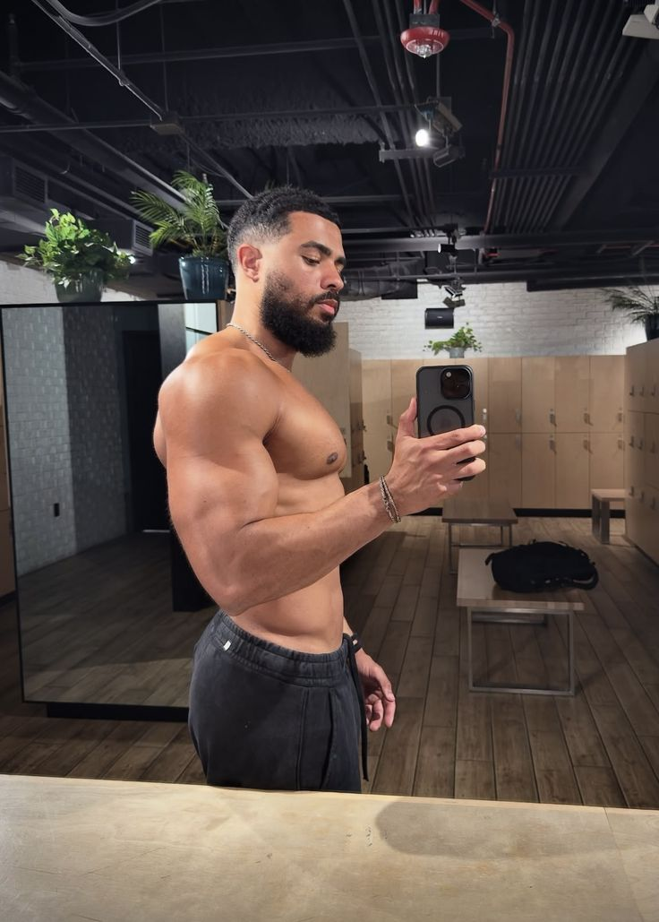 Man in a gym mirror showing a clean haircut and athletic frame