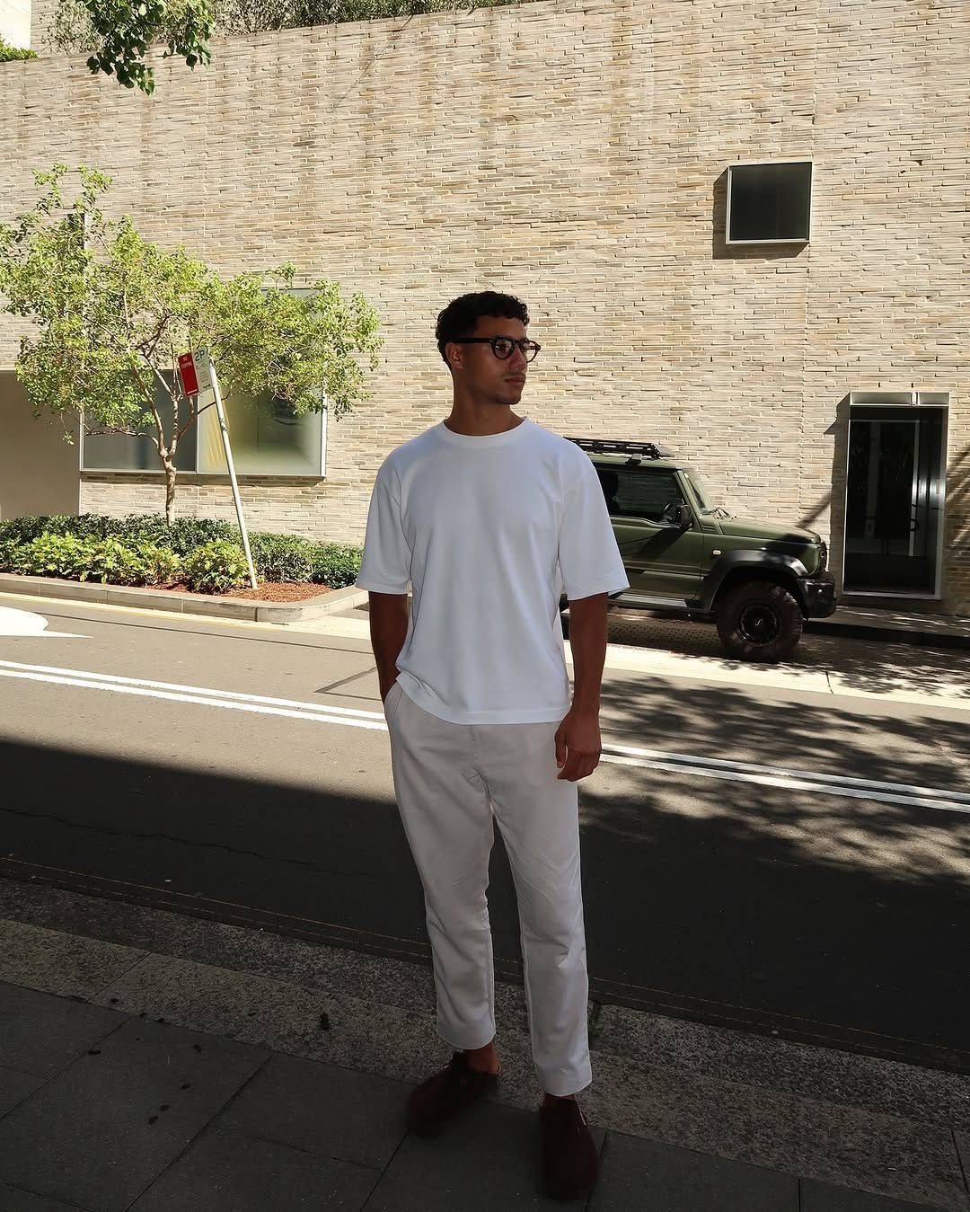 Man wearing a clean white tee and light pants outside